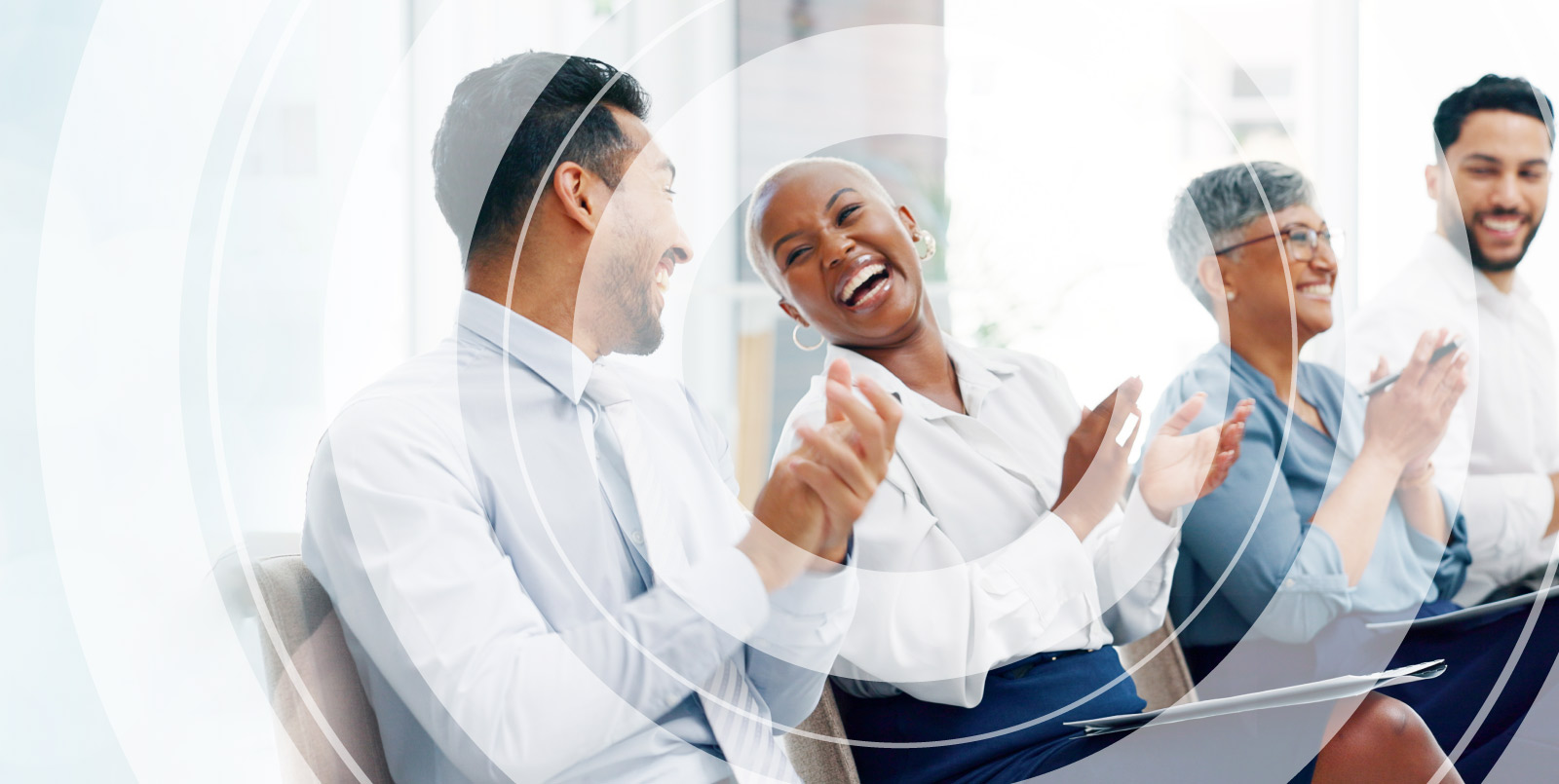 Group of four people in business clothes sitting together, talking and laughing